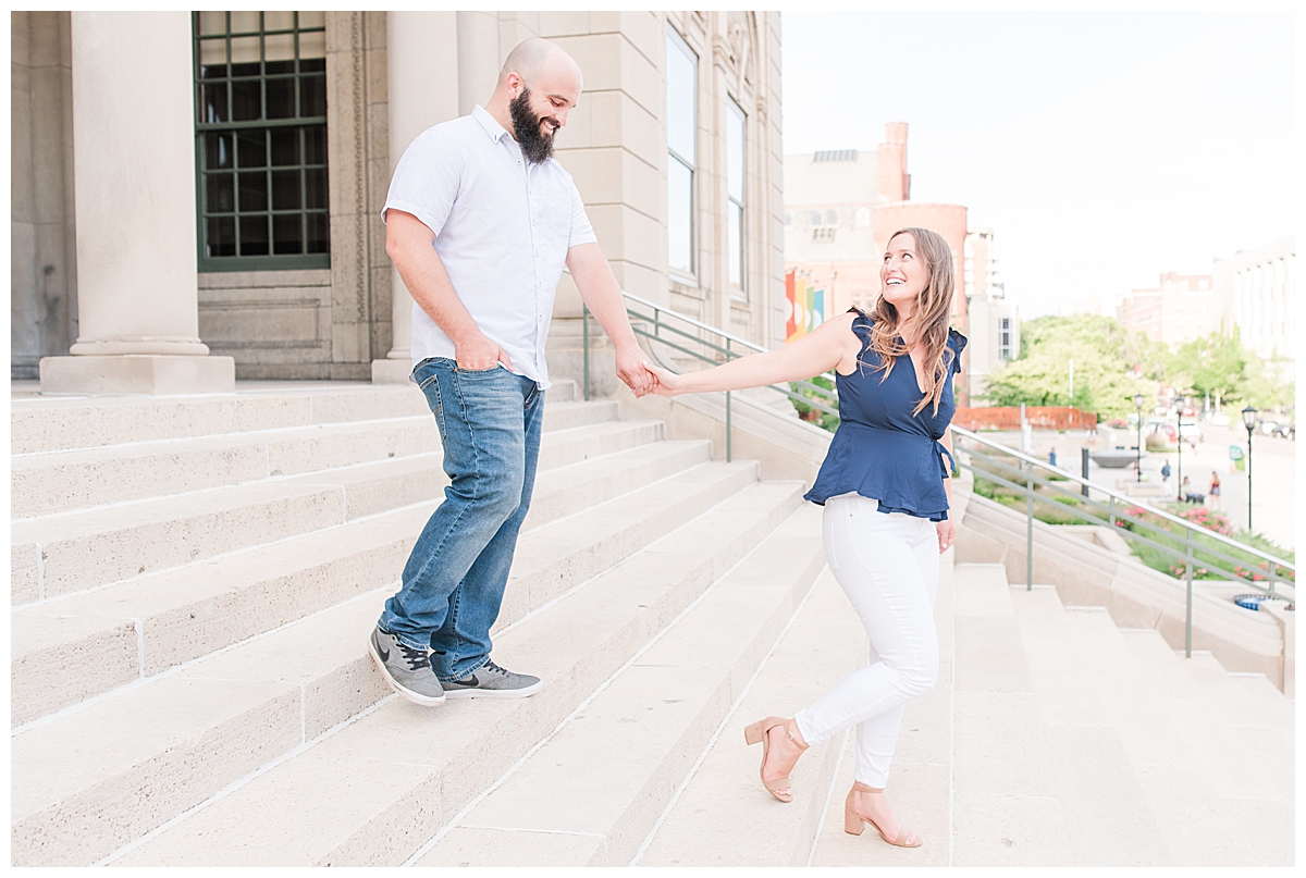 A couple holding hands, walking down an outdoor staircase for their Madison engagement photos