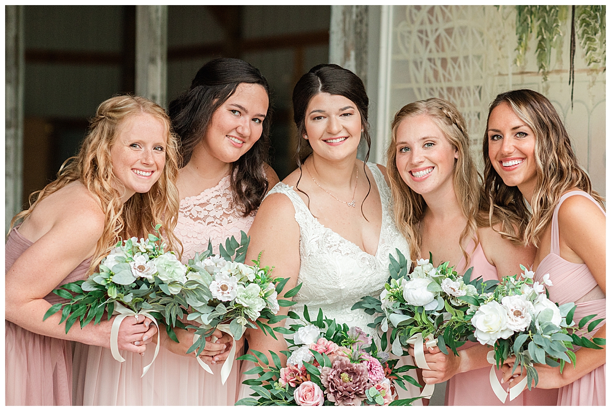 bride and bridesmaids smiling together at the country reflections wedding venue near la crosse, wi