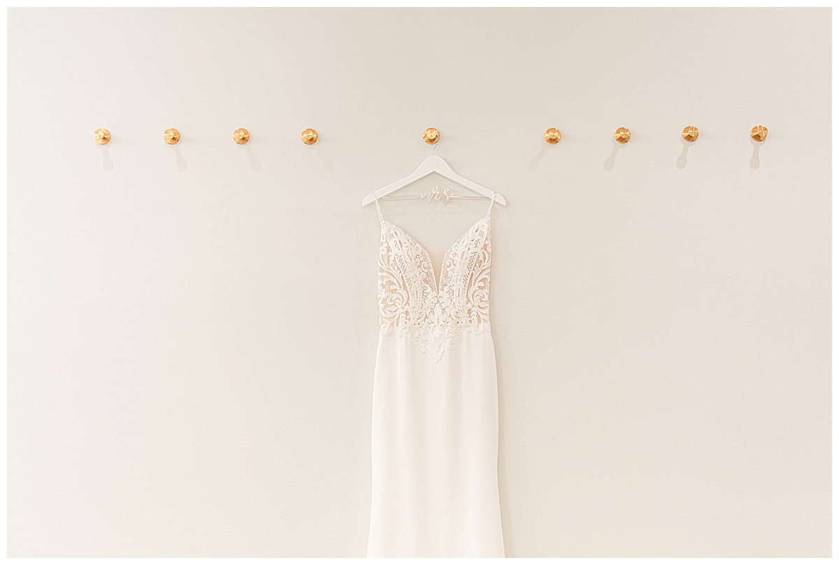 A wedding dress hanging by Madison Wedding Photographer Morgan Madeleine Photography