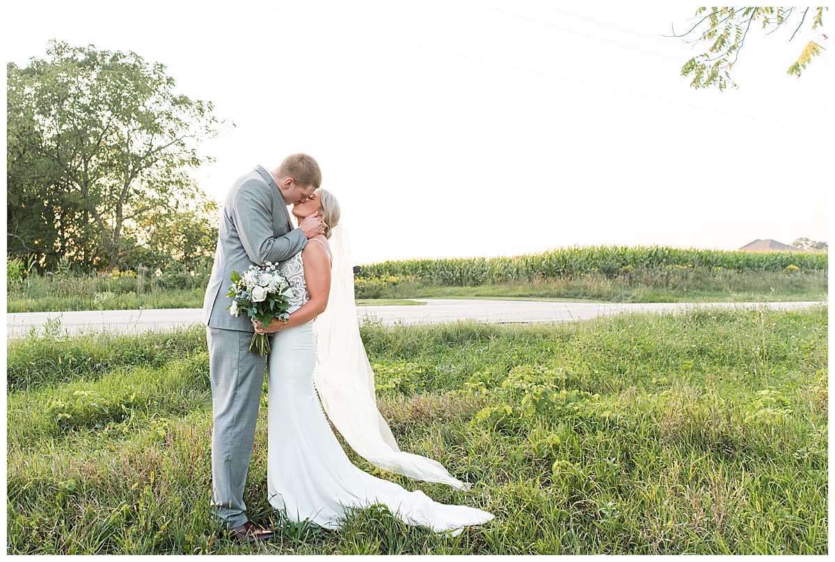 ngBride and groom kissing at sunset outside of The Eloise, a modern barn venue near Madison, Wisconsin