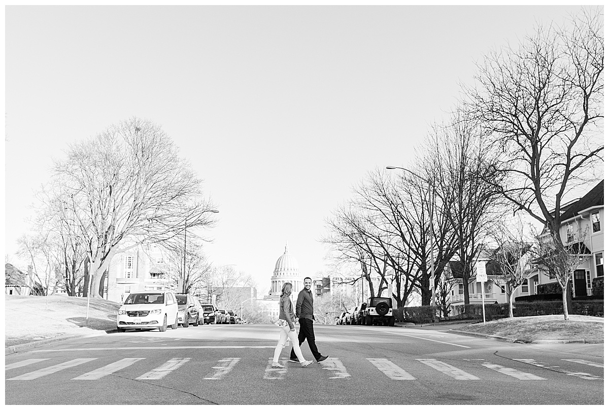 black and white photo of couple in crosswalk in front of madison capitol building for engagement photos