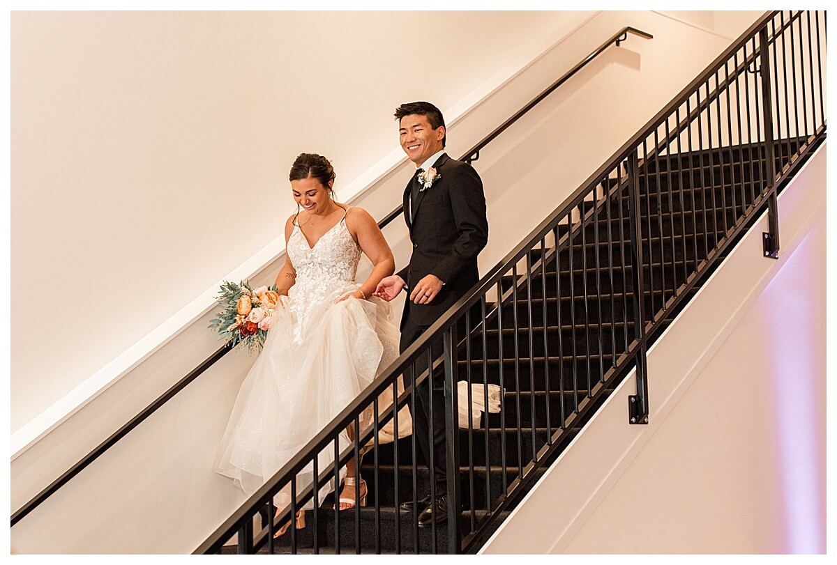 bride and groom walking down the staircase inside the eloise