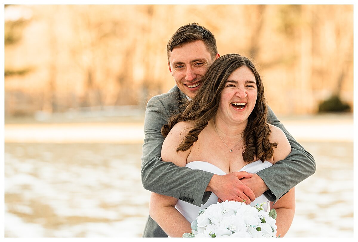 bride and groom hug and laugh together at a wilderness resort wedding in the dells