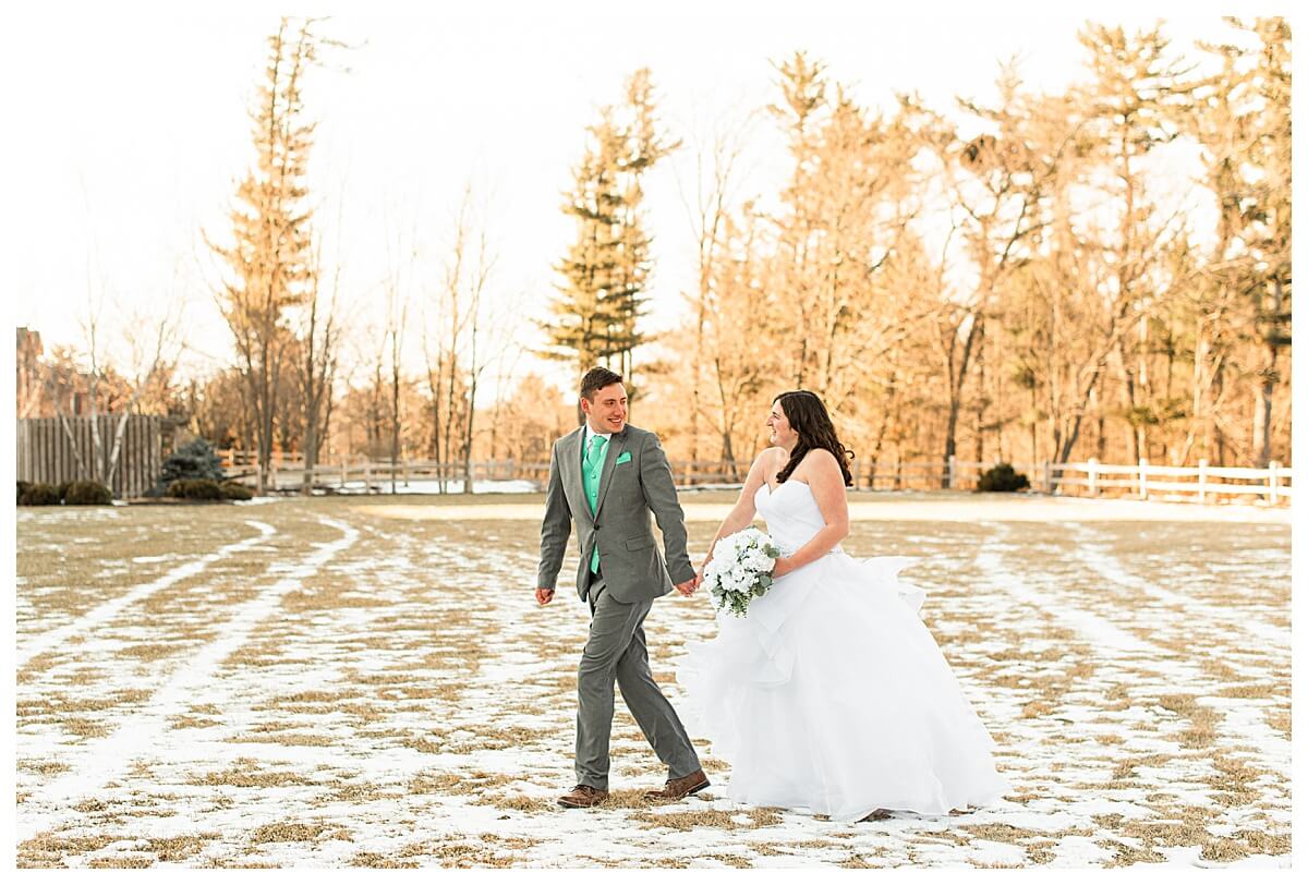 bride and groom hold hands, walking through a field at the wilderness resort in the dells