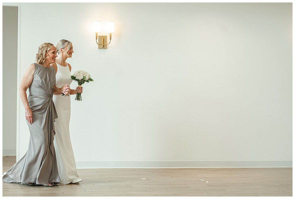 Bride smiling while walking down the aisle inside The Eloise Wedding Venue outside Madison, WI