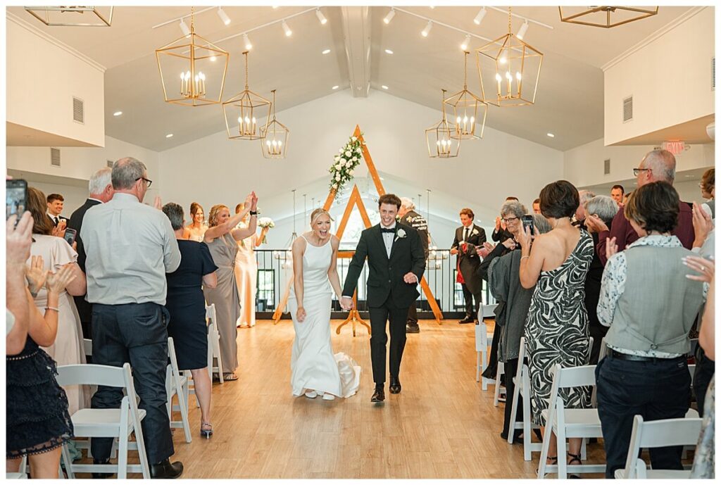 Bride and groom running joyfully up the aisle at The Eloise Mt Horeb