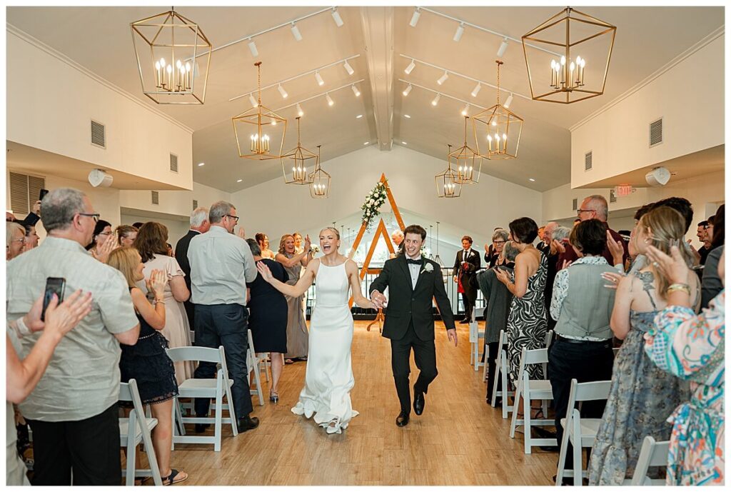 Bride and groom running joyfully up the aisle at The Eloise wedding venue