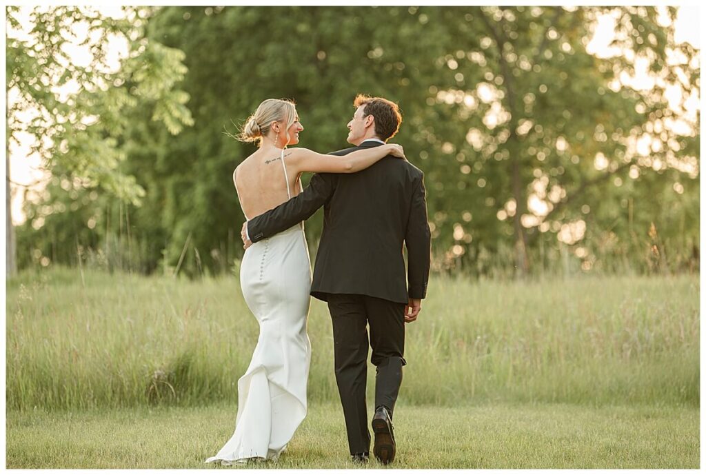 Couple walking through the fields at The Eloise Wedding Barn in Mt Horeb