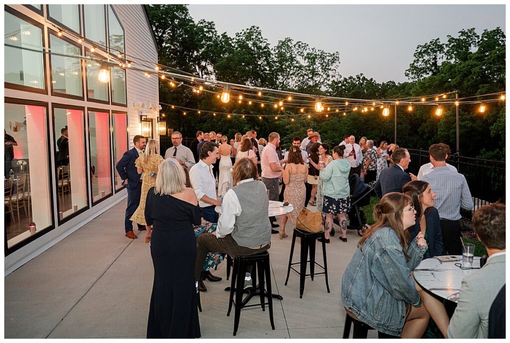 Guests enjoying cocktail hour on the patio at The Eloise Wedding Barn